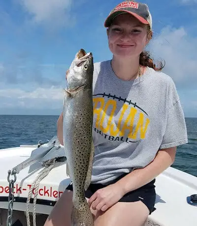 Young lady hold a Hatteras Island Speckled Trout she caught.