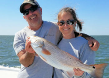 Father and daughter with a nice Red Drum she caught.